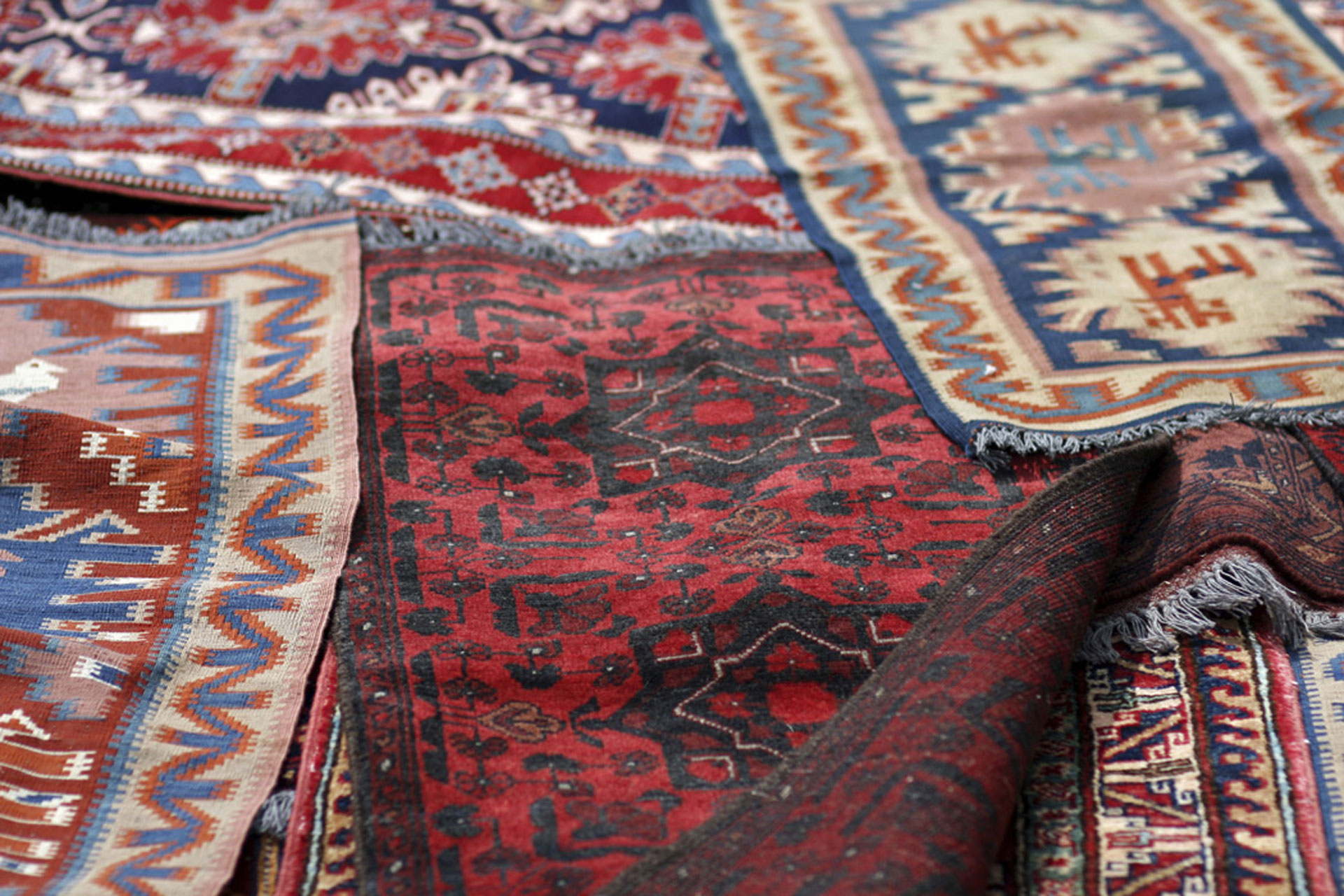 Antique area rugs in a pile